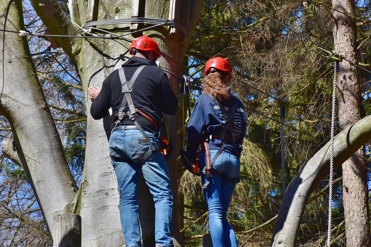 2 Erwachsene vor der nächsten Herausforderung im Hochseilgarten