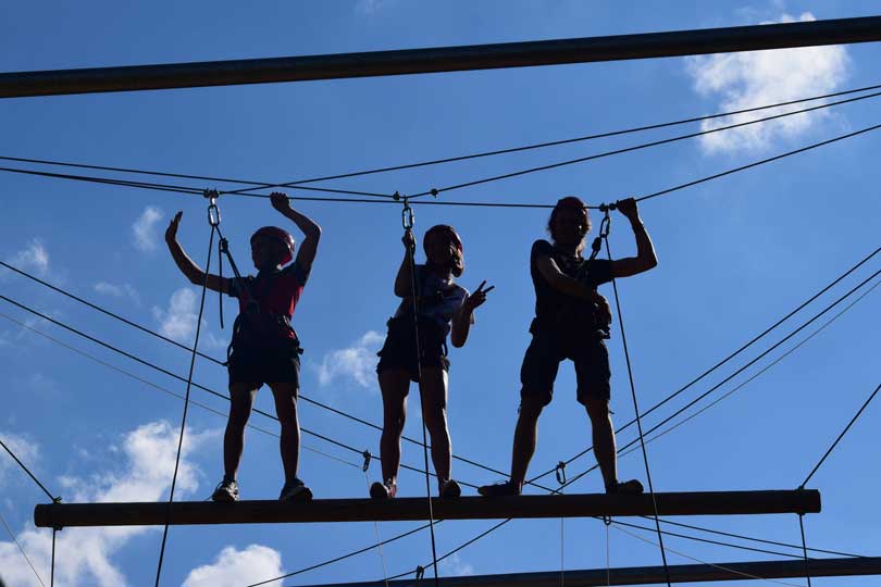 3 Jugendliche im Hochseilgarten: darüber nur noch der Himmel