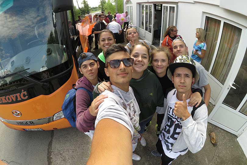 Internationale Jugendgruppe macht Selfie vor dem Reisebus