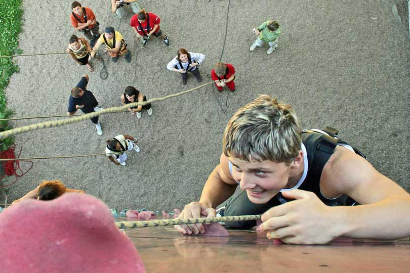 Jugendlicher ganz oben an der Kletterwand